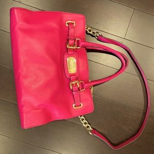 Pink Michael Kors purse with gold trim.